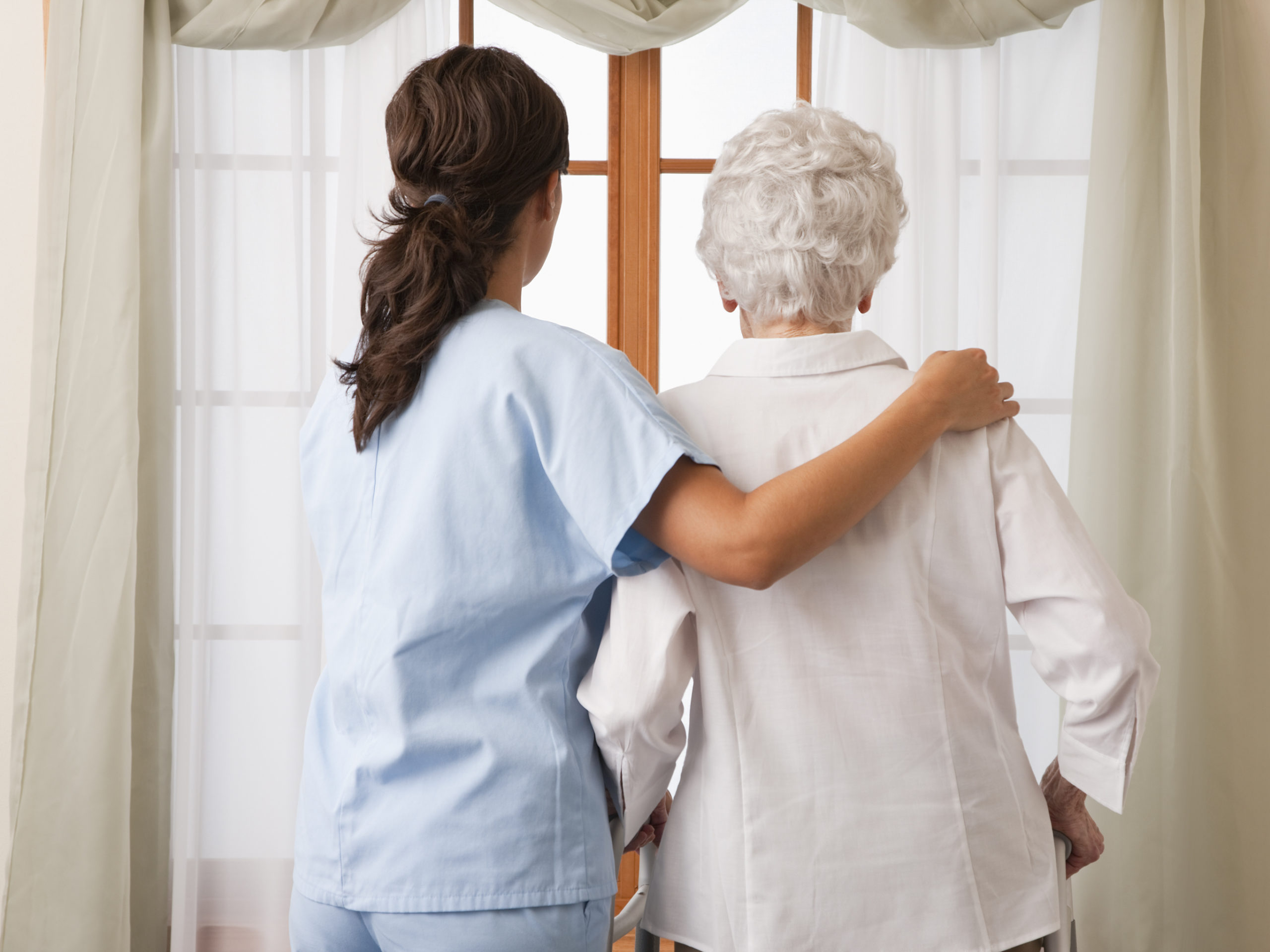 Nurse with arm around elderly patient